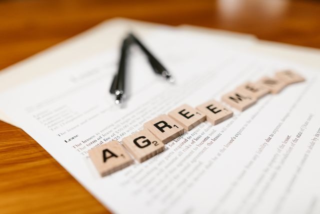 word agreement spelled out with wooden tiles on documents