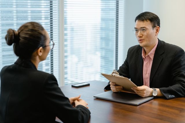 two people taling over a desk