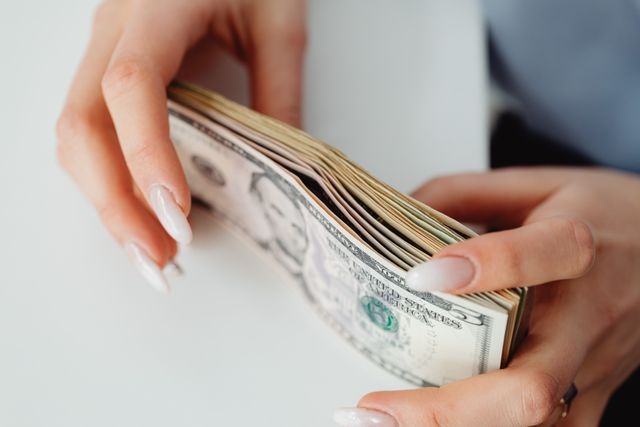person holding a stack of money 