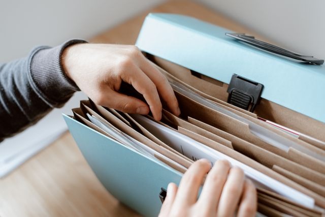 person looking through a filing box