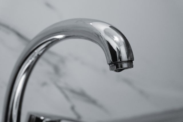 a stainless steel faucet dripping water