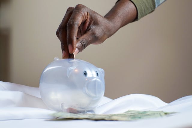 Person putting money in a piggy bank