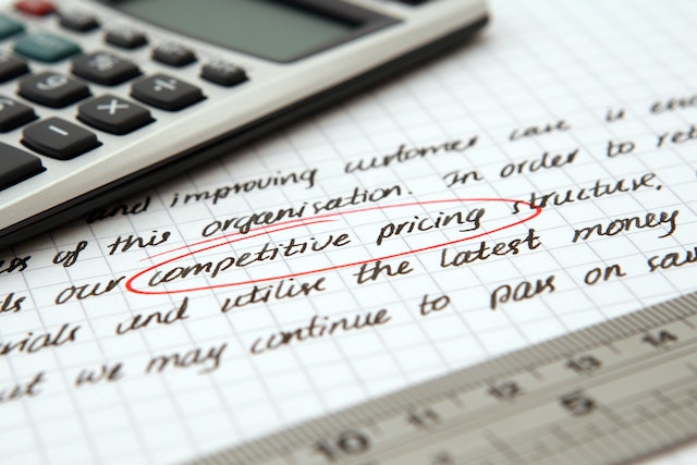 a calculator on a piece of paper with the words competitive pricing circled in red
