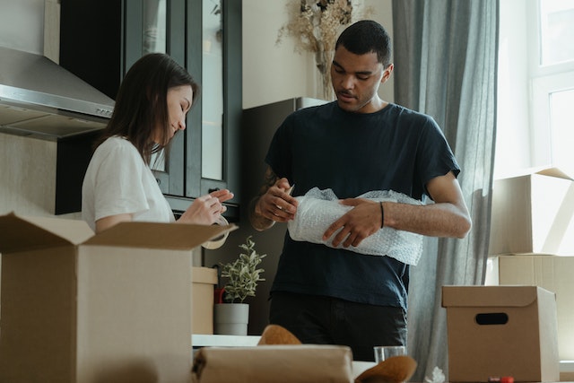 a couple of tenants packing up belongings and putting them in moving boxes