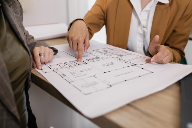 a property manager and property owner looking over a home's blueprints