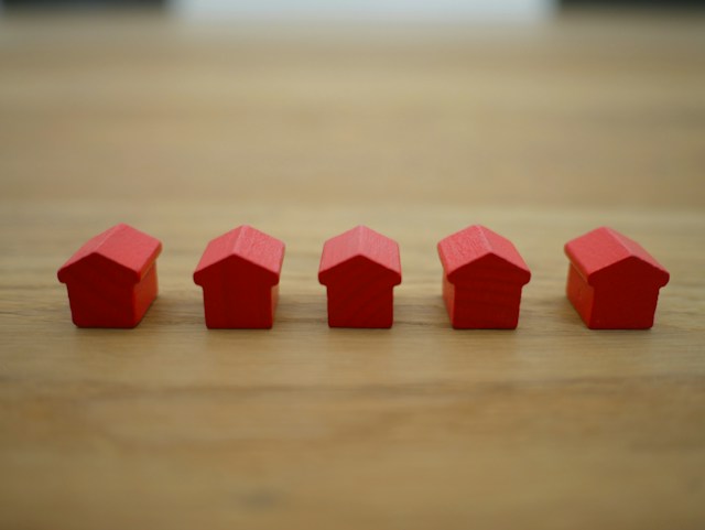 five little red home figurines in a row