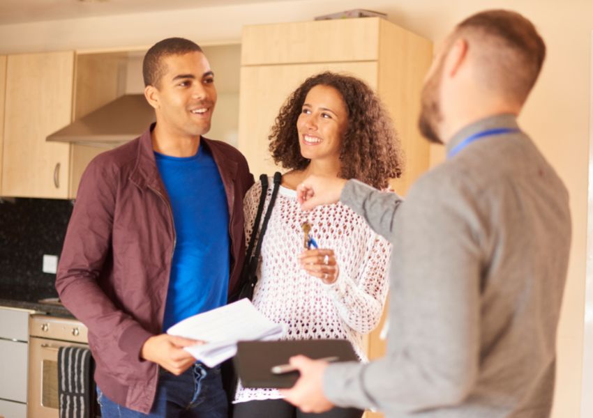 landlord passing two tenants the keys to their new rental property