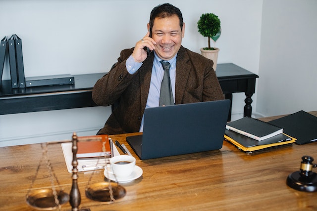 lawyer on the phone with a legal balance on their desk