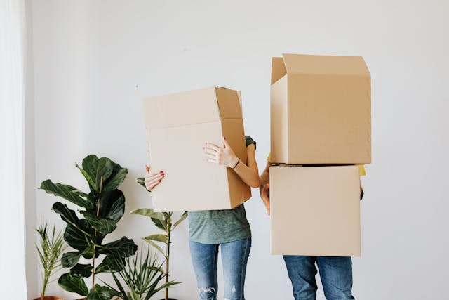 people carrying large moving boxes