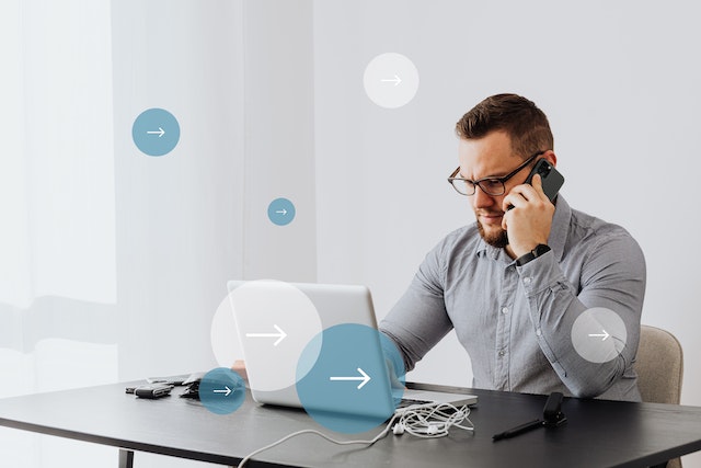 person sitting at their desk while talking on the phone