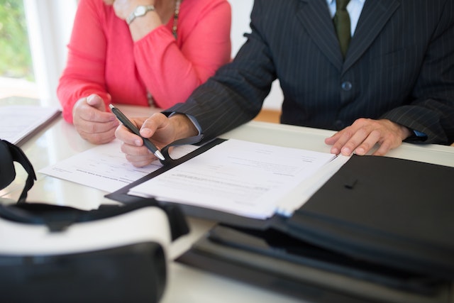 two people looking over a rental agreement while sitting at a desk