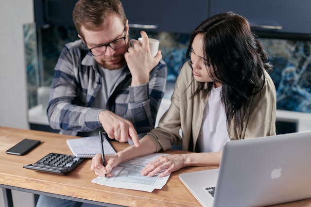 two people writing on documents