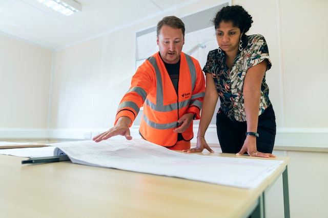 two property experts looking over the blueprint of a home to assess issues of structural integrity